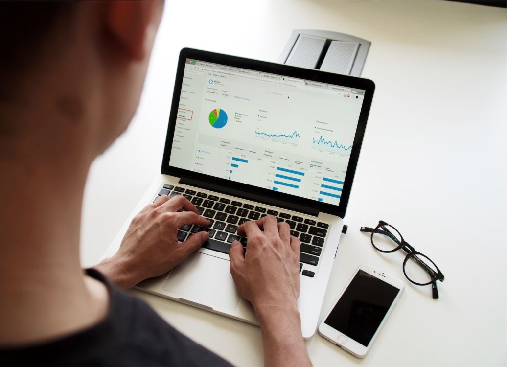 Mann, der sich auf dem Laptop Diagramme und Analysen ansieht