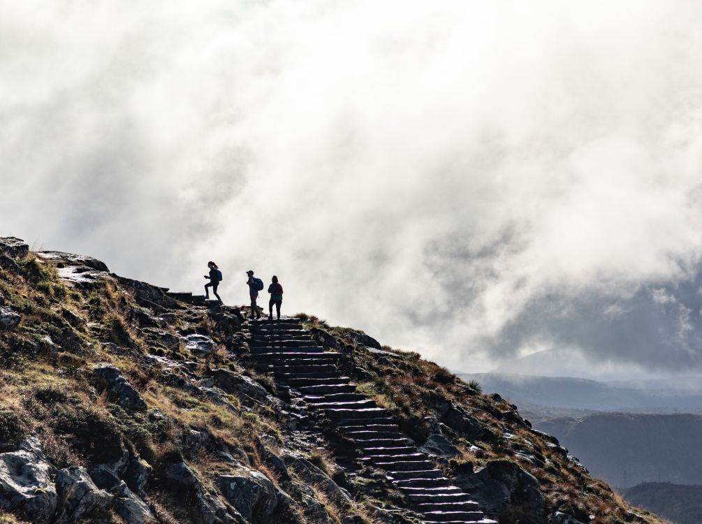 Drei Menschen, die einen Berg besteigen