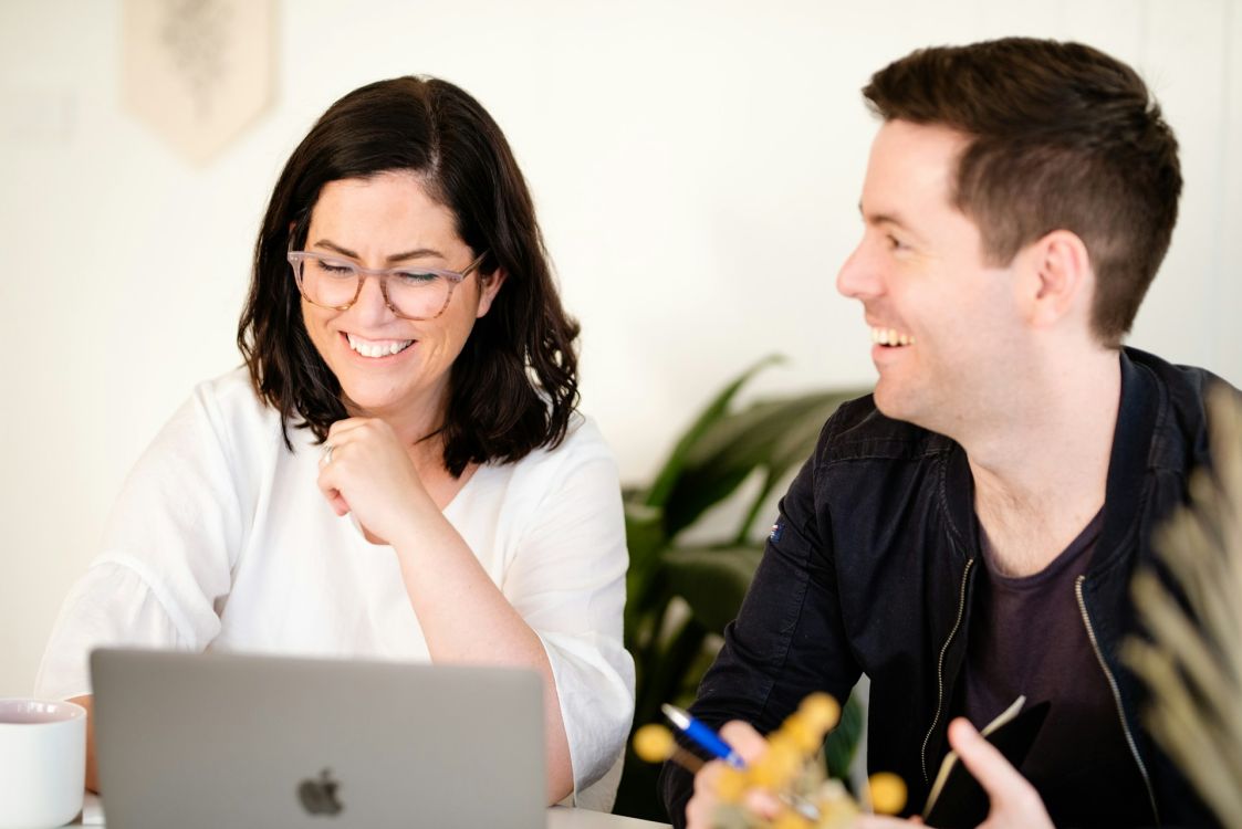 Ein Mann und eine Frau schauen fr&ouml;hlich auf einen Laptop