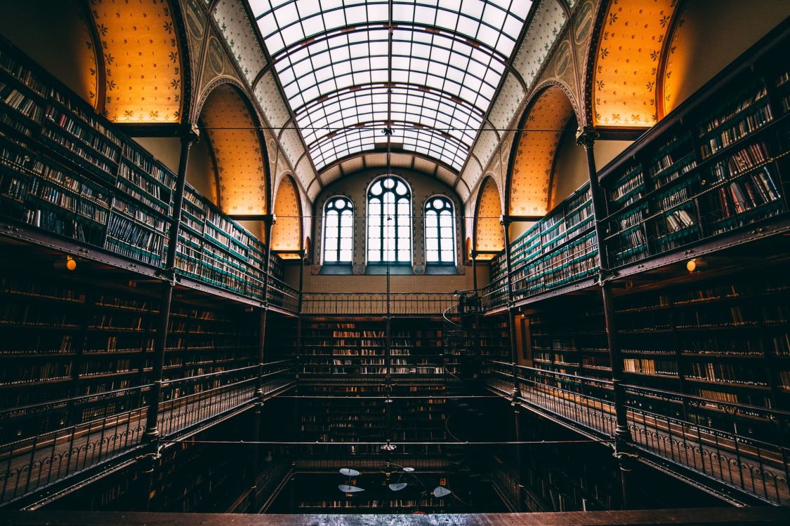 Bücherei in einem alten, schönen Gebäude, Fenster in der Mitte, links und rechts Regale voller Bücher
