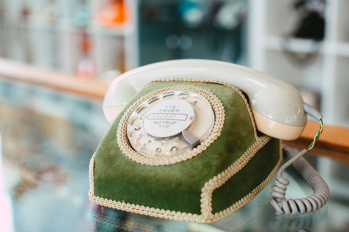 Altmodisches, grünes Telefon mit Wählscheibe