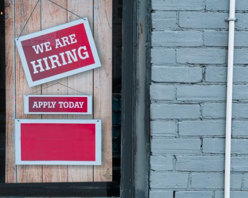Schild an Tür "We are hiring - apply now"