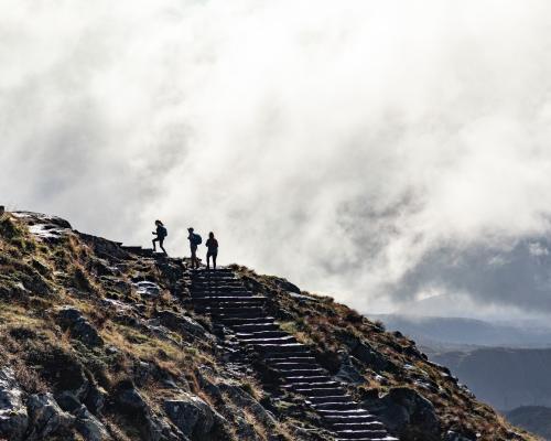 Drei Menschen, die einen Berg besteigen