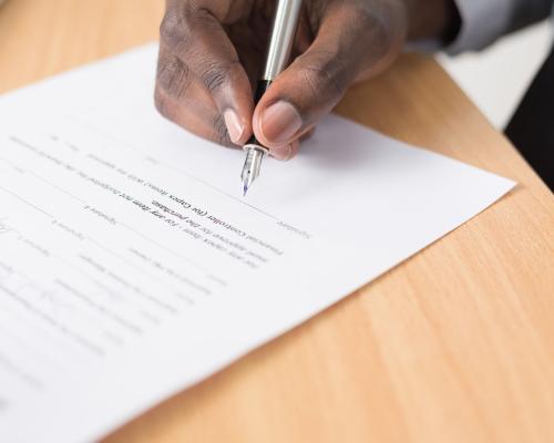 Hand mit Füller unterschreibt ein Dokument